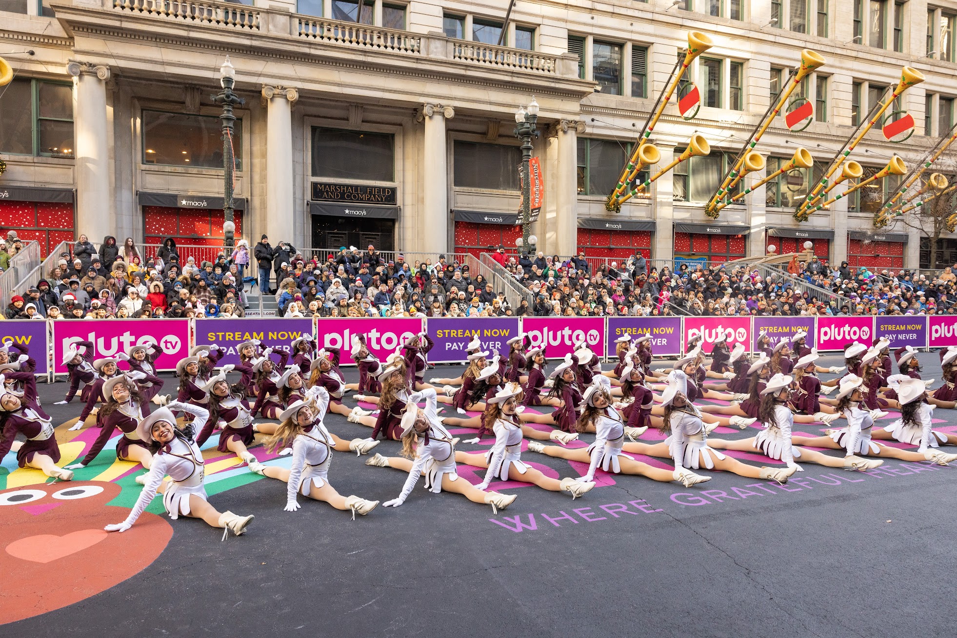 The Texas State Strutters, all in splits, conclude their performance during the 2023 Chicago Thanksgiving Parade.